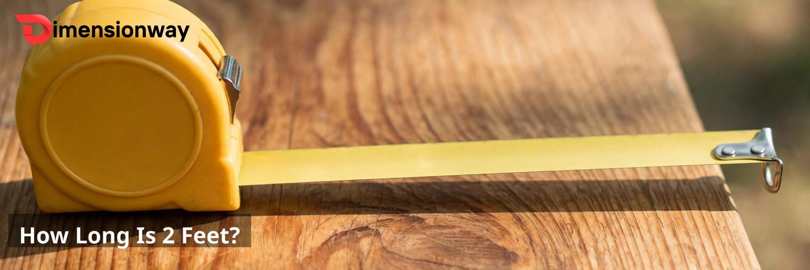 A tape measure stretched out to two feet on a wooden table.