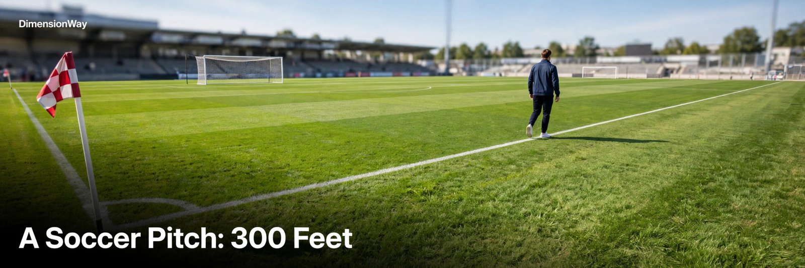 Person walking along the touchline of a full-size soccer pitch.