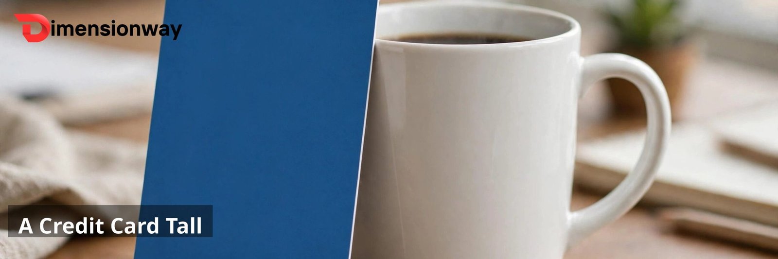 A credit card standing vertically against a white ceramic coffee mug on a desk.